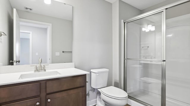 bathroom with walk in shower, vanity, and toilet