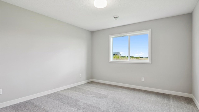 carpeted spare room featuring a textured ceiling