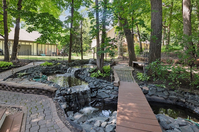 view of property's community with a garden pond