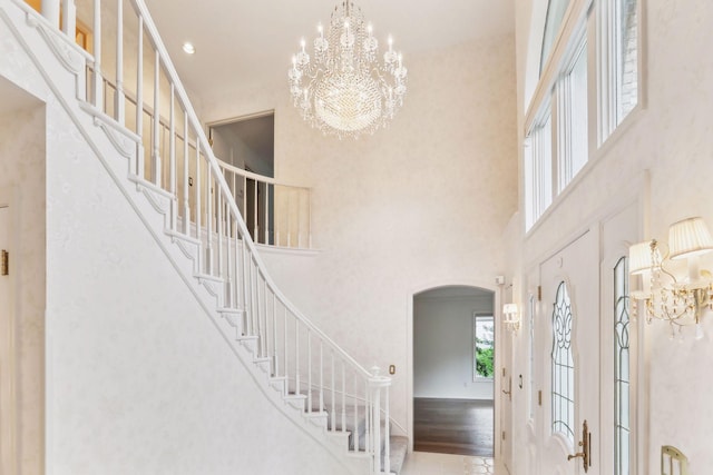 entrance foyer with crown molding, a notable chandelier, and a high ceiling