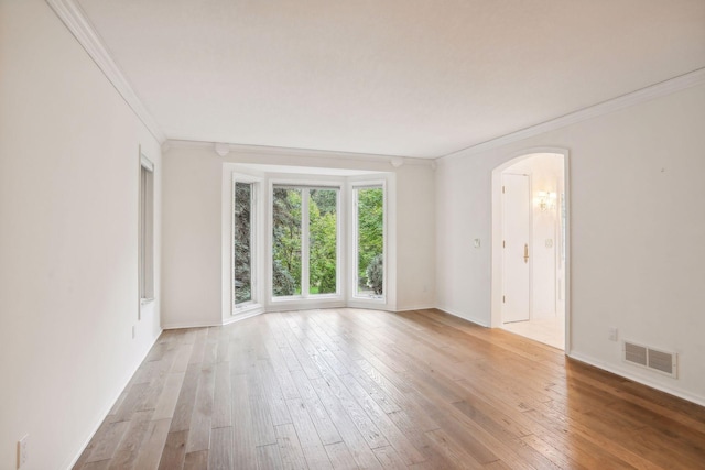 empty room featuring ornamental molding and light hardwood / wood-style floors