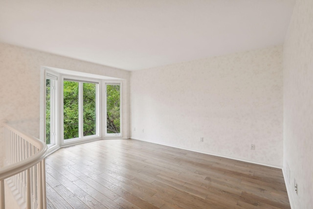 spare room featuring hardwood / wood-style flooring and a healthy amount of sunlight