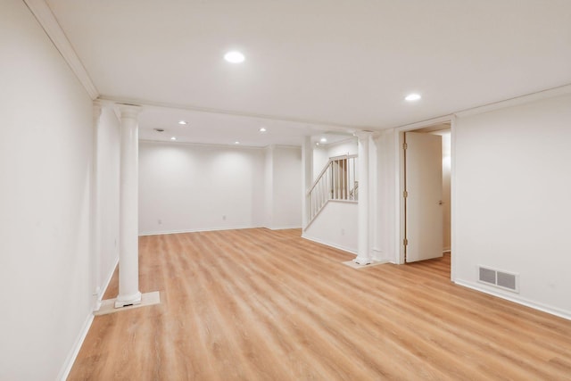 basement with ornamental molding and light hardwood / wood-style floors