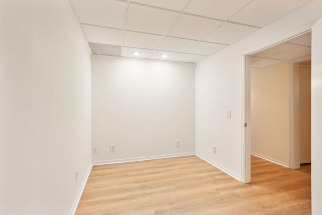 spare room with a paneled ceiling and light hardwood / wood-style flooring