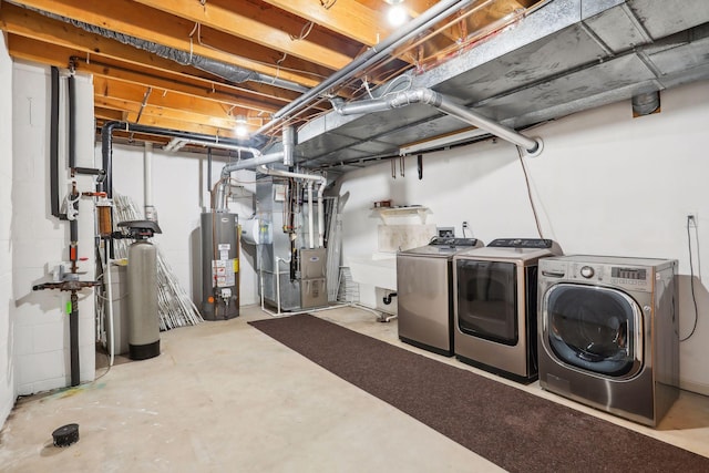 basement featuring washer and dryer, heating unit, and water heater