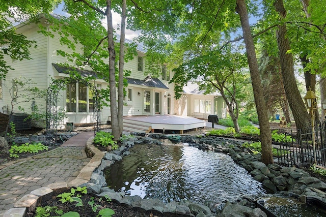 back of house with a garden pond and a deck