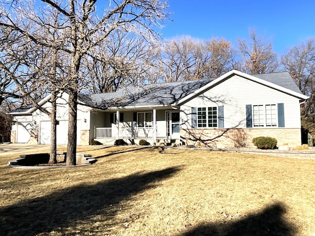 ranch-style house featuring a porch, a garage, and a front lawn