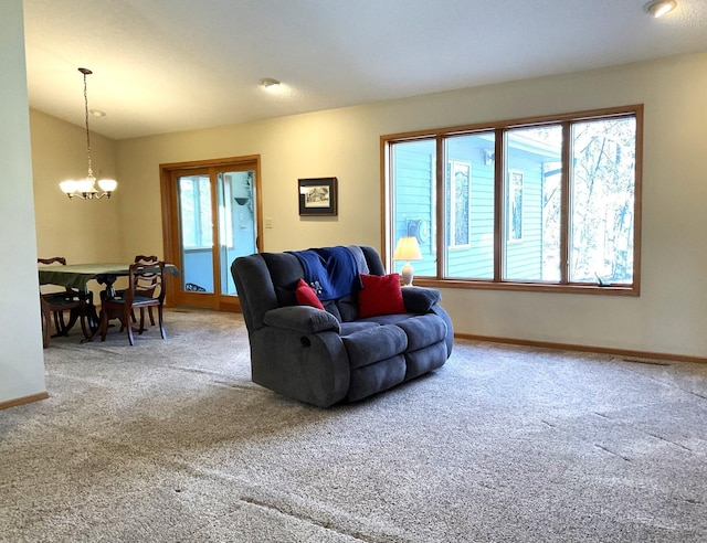 carpeted living room with plenty of natural light and a chandelier