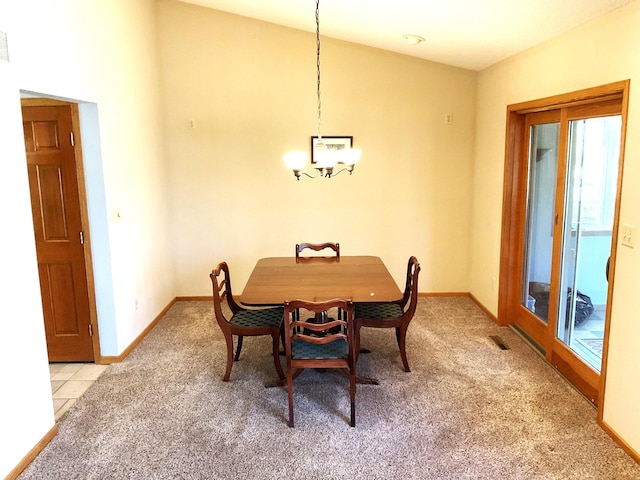 dining space with light carpet and a notable chandelier