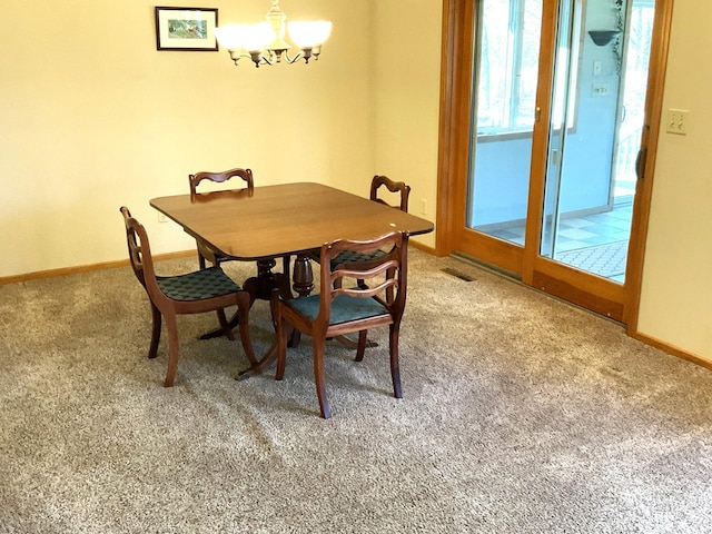 dining room with a notable chandelier and carpet floors