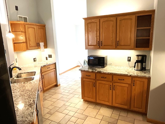 kitchen featuring light stone counters and sink