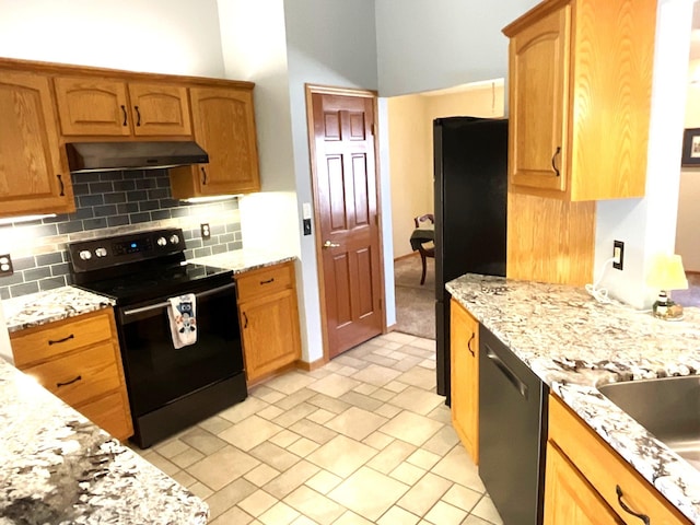 kitchen with tasteful backsplash, light stone countertops, and black appliances