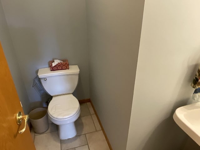 bathroom featuring sink, toilet, and tile patterned flooring