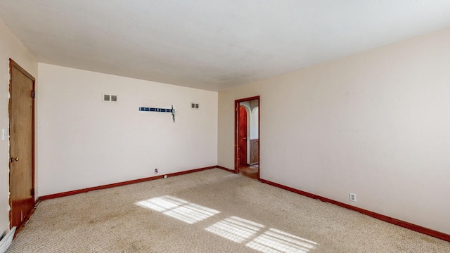 spare room featuring light colored carpet