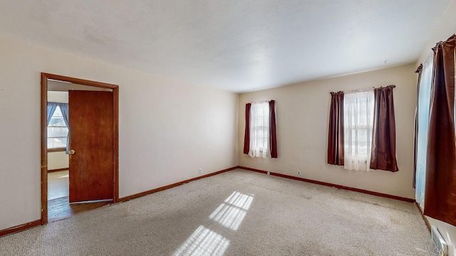 carpeted spare room featuring a wealth of natural light