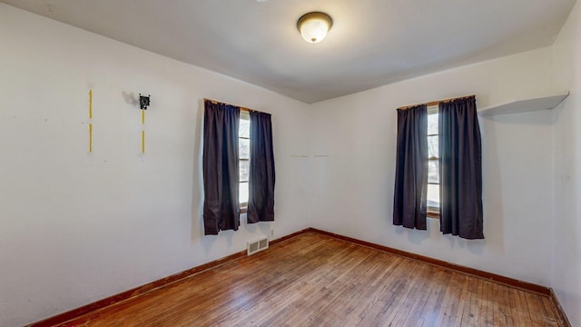 empty room featuring a healthy amount of sunlight and hardwood / wood-style floors