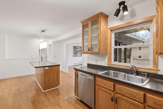 kitchen featuring sink, stainless steel dishwasher, hanging light fixtures, and light wood-type flooring