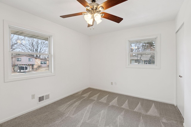 carpeted spare room featuring ceiling fan