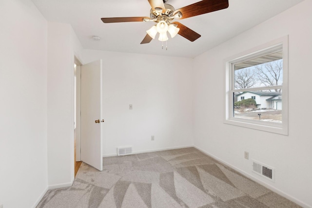 carpeted spare room featuring ceiling fan