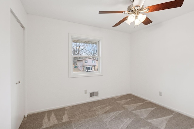 unfurnished room with ceiling fan and carpet