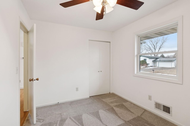 unfurnished room featuring light colored carpet and ceiling fan