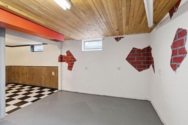 basement featuring wood ceiling and wood walls