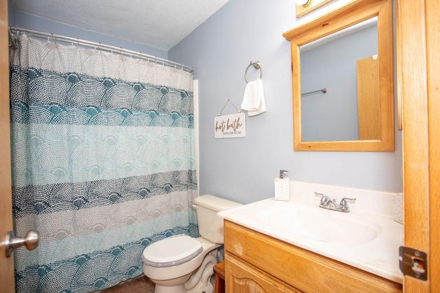 bathroom featuring vanity, walk in shower, and toilet