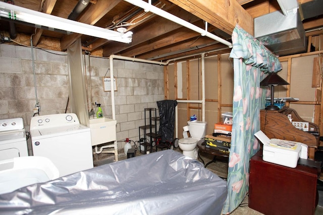 basement featuring separate washer and dryer and sink