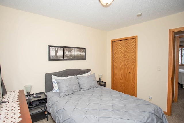 carpeted bedroom featuring a closet and a textured ceiling