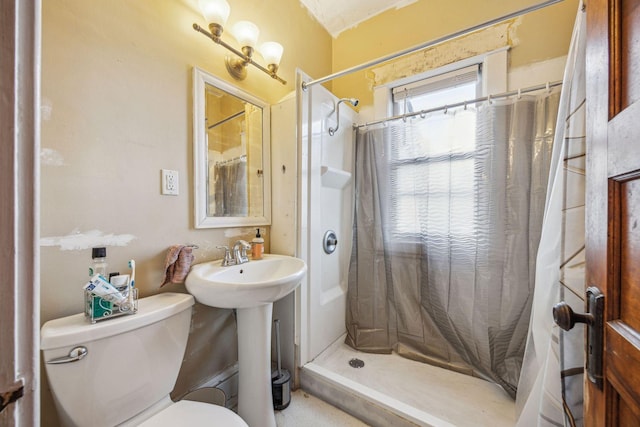 bathroom with curtained shower, a sink, and toilet