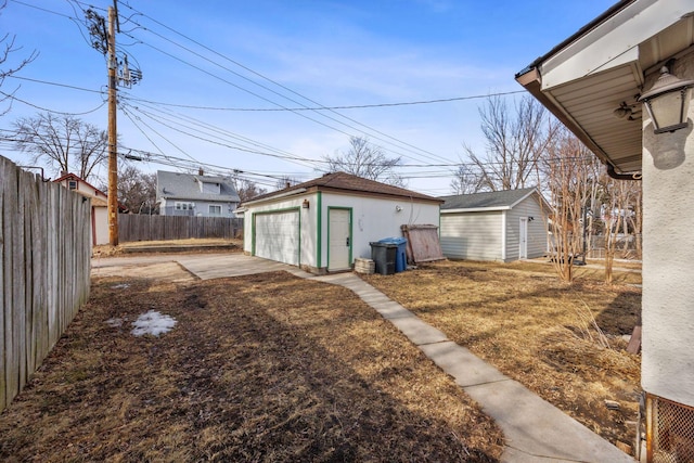 view of yard with a garage, an outdoor structure, and a fenced backyard