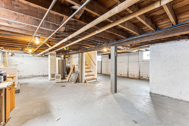 basement with water heater and stairway