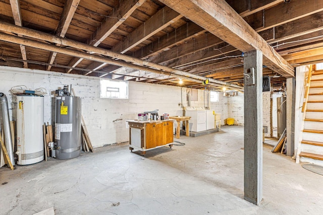 basement with washing machine and dryer, water heater, stairs, and electric water heater