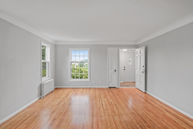 empty room with radiator and light wood-type flooring