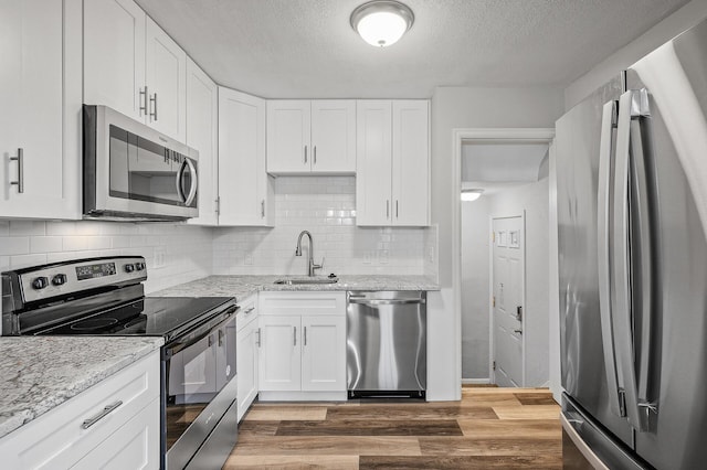 kitchen with sink, a textured ceiling, white cabinets, and appliances with stainless steel finishes