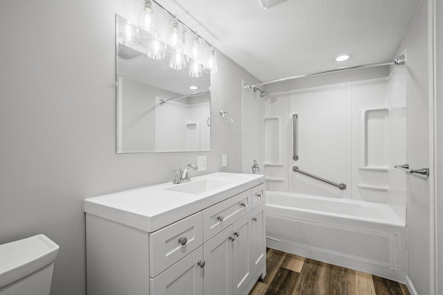 full bathroom with toilet, a textured ceiling, shower / bathtub combination, vanity, and hardwood / wood-style flooring