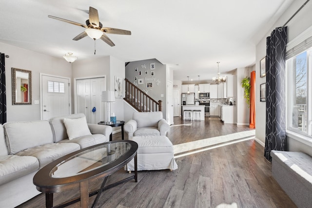 living room featuring dark hardwood / wood-style flooring and ceiling fan with notable chandelier