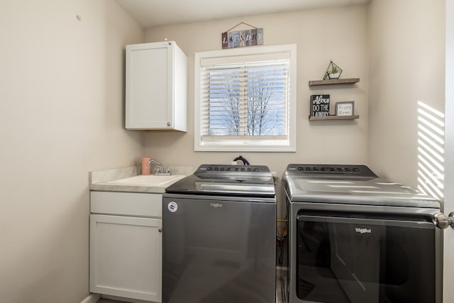 laundry area featuring cabinets, washing machine and clothes dryer, and sink