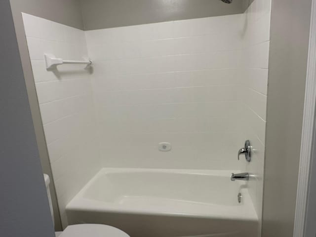 bathroom featuring shower / washtub combination and toilet