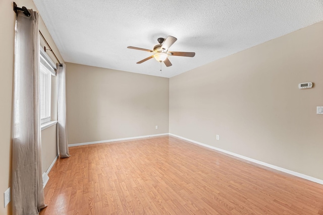 spare room with ceiling fan, light hardwood / wood-style floors, and a textured ceiling