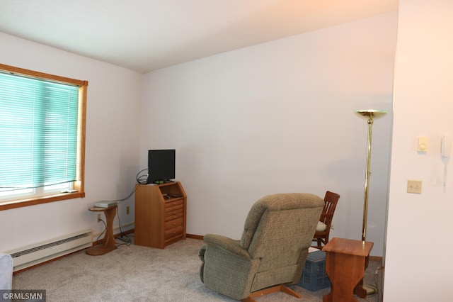 living area featuring a baseboard heating unit and light carpet