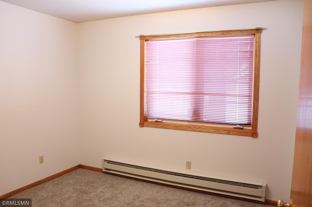 empty room featuring a baseboard heating unit and carpet flooring