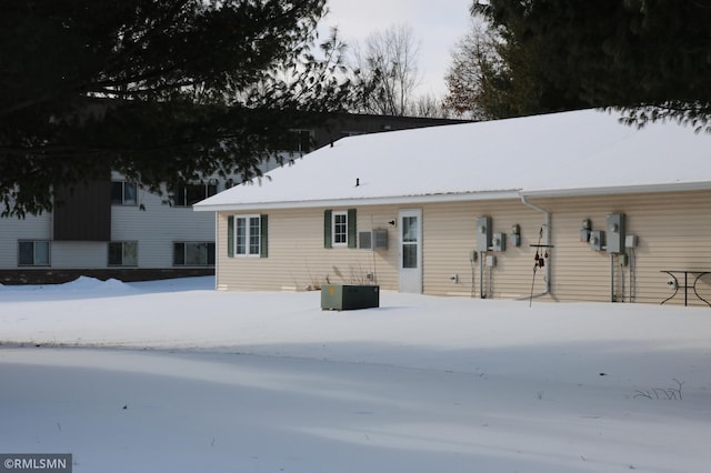 snow covered house with central air condition unit