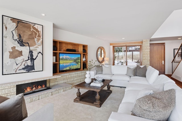 living room featuring recessed lighting and a lit fireplace