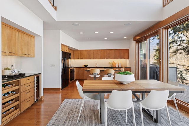 dining room featuring wood finished floors, recessed lighting, beverage cooler, and baseboards