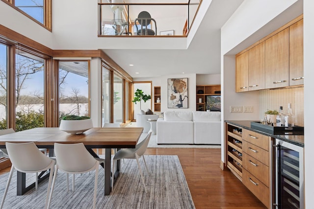 dining area with wood finished floors, recessed lighting, and beverage cooler