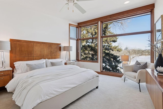 bedroom with light carpet, multiple windows, and ceiling fan