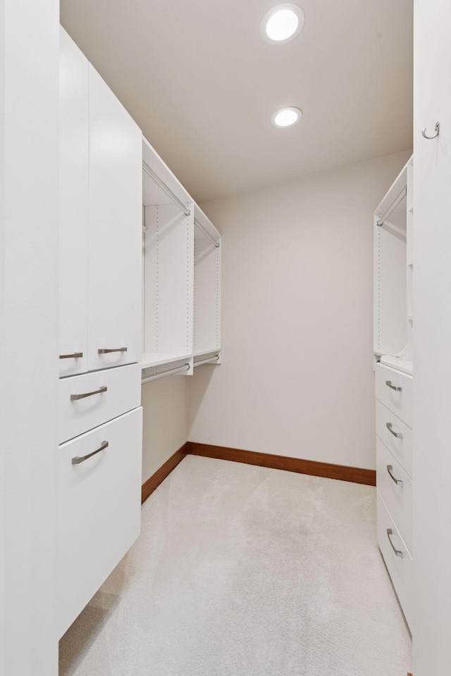 walk in closet with light carpet