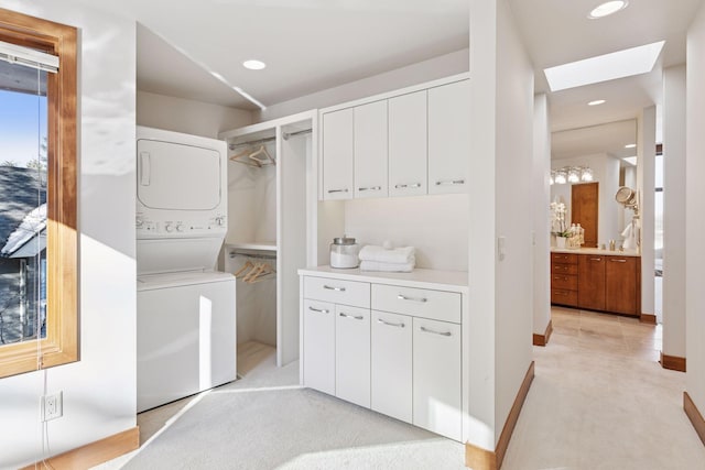 clothes washing area with light carpet, laundry area, recessed lighting, stacked washer and clothes dryer, and a skylight