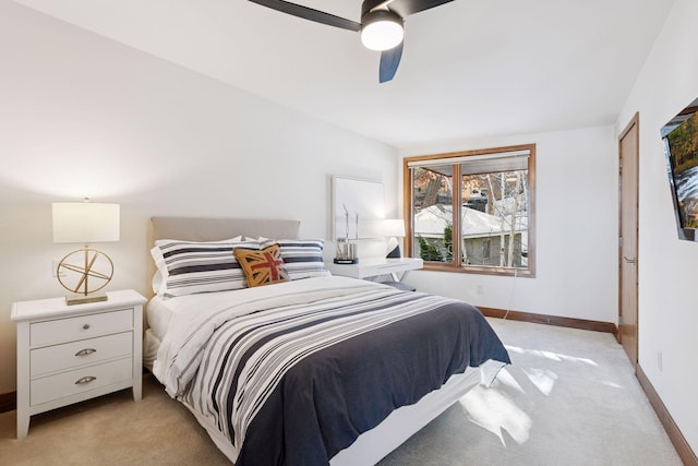 bedroom with light colored carpet, a ceiling fan, and baseboards